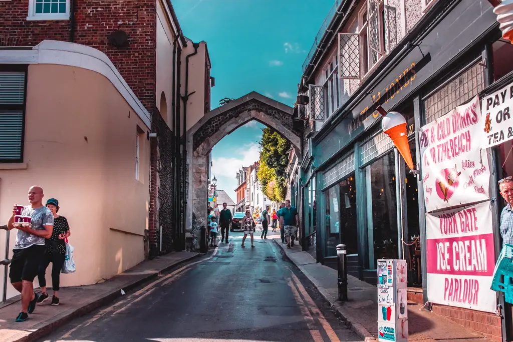 A small road with an arch and people walking on the street at Broadstairs.