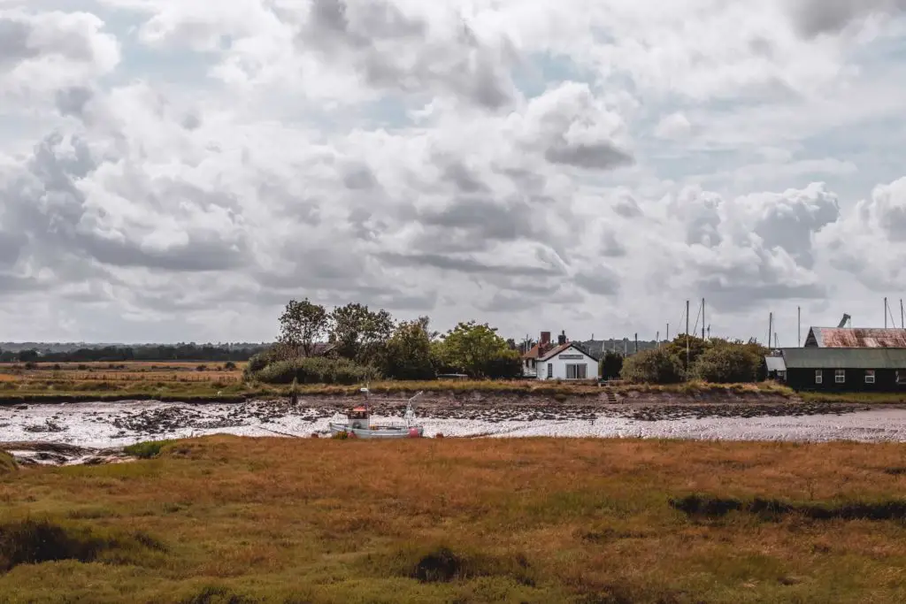 A farm house on the side of the muddy creek.