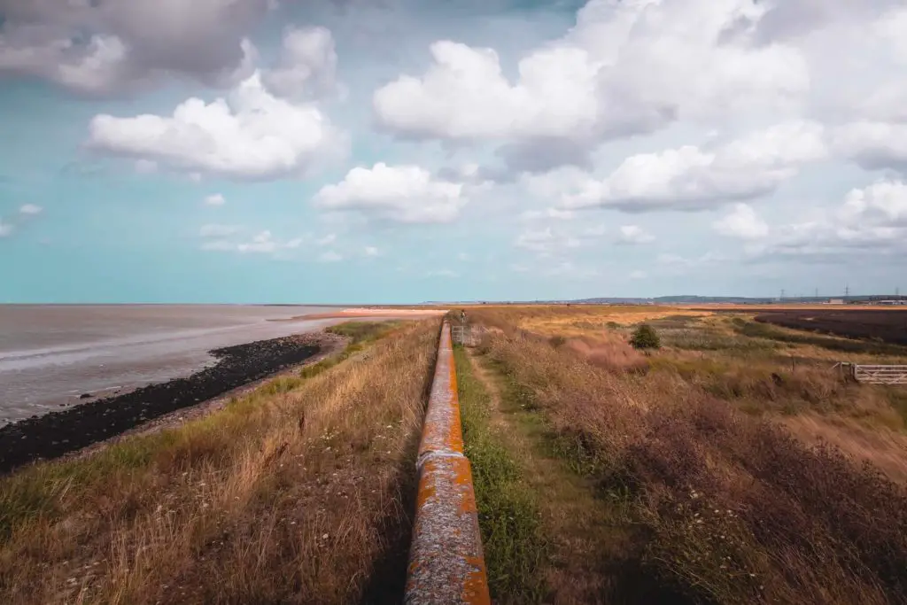 The sea wall with the Swale to the left and fields to the right on the walk from Faversham to Whitstable. 