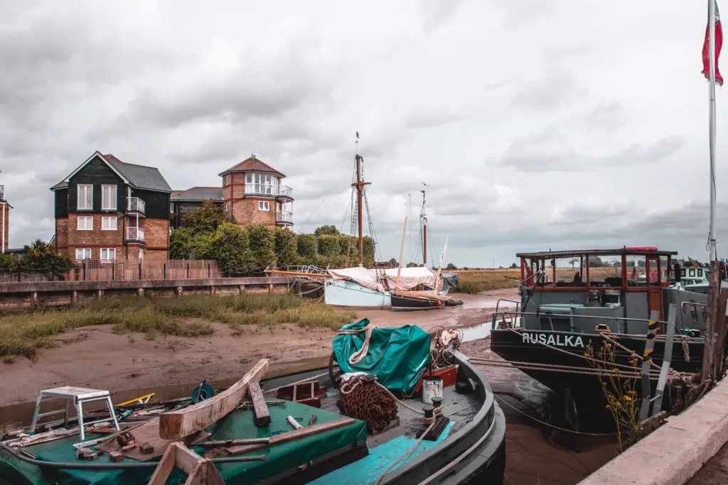 Boats and barges on the river bed at low tide.