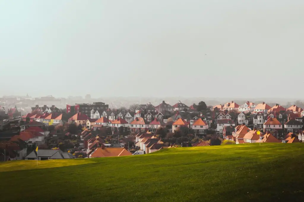 A green field leading to a rooftop view over Folkestone.