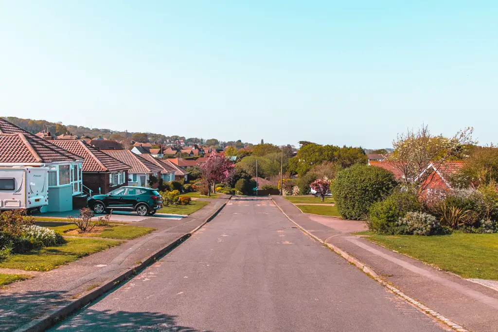 A suburban scene of a residential road with houses. 