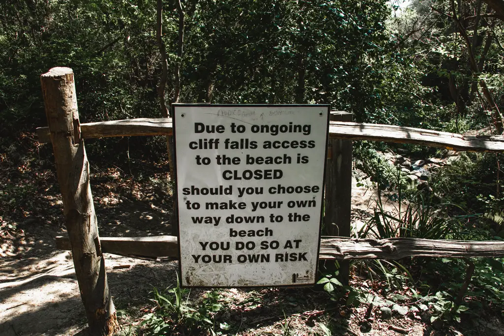 Warning sign of the dangers of cliff falls if going to the beach.