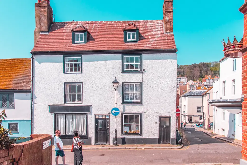 In the streets of Hastings old town, a photo of a white walled house with a blue sky back drop.