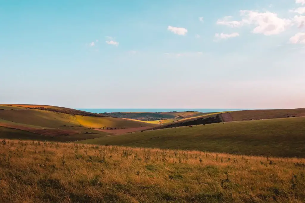 The rolling hills of different shades of green, orange and brown as they crisscross in the valley.