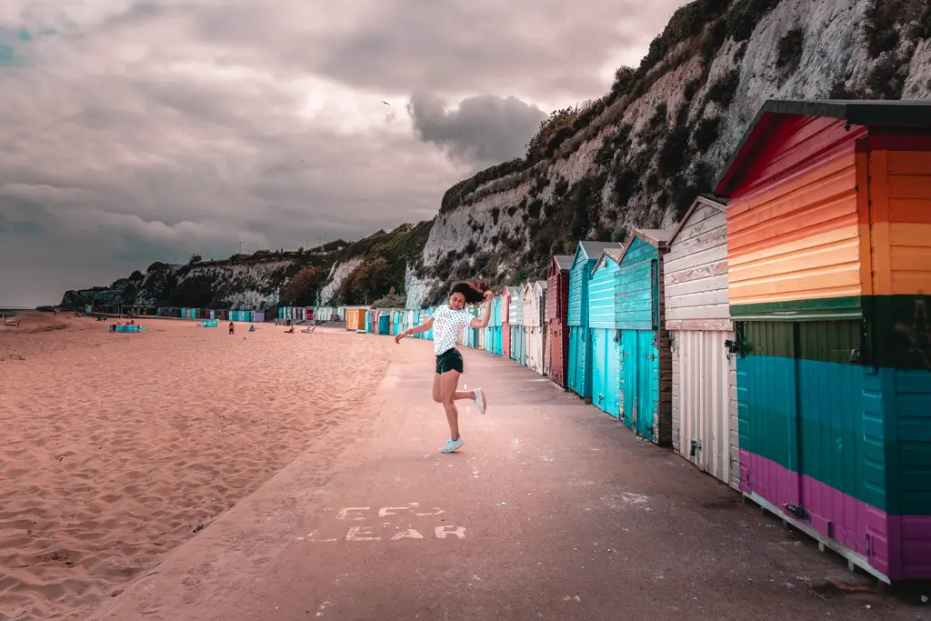 Zoe posing on the path next to all the colourful beach huts on the walk from Margate to Broadstairs.