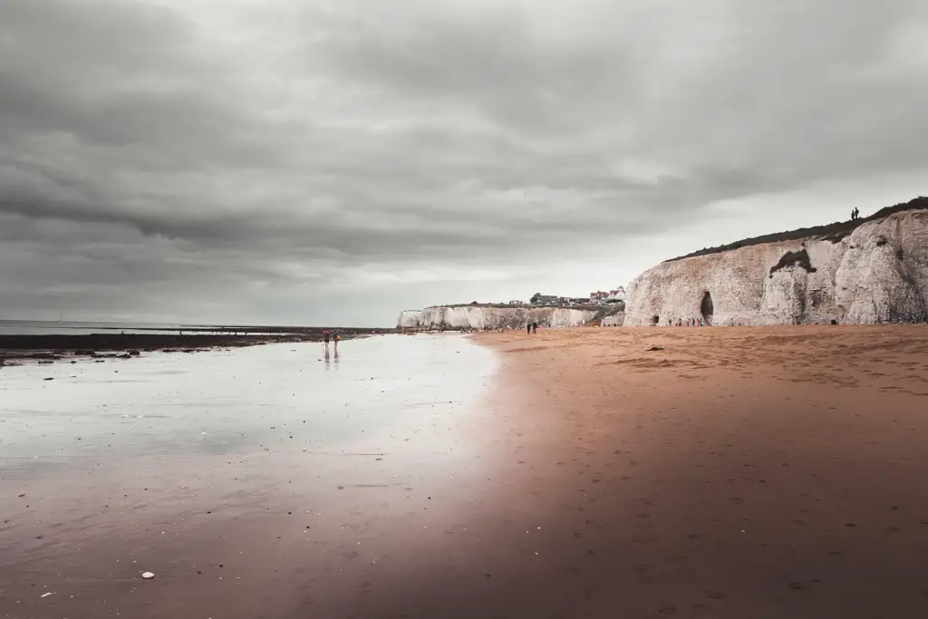 A sandy beach under the white cliffs on a cloudy day when walking from Margate to Ramsgate.