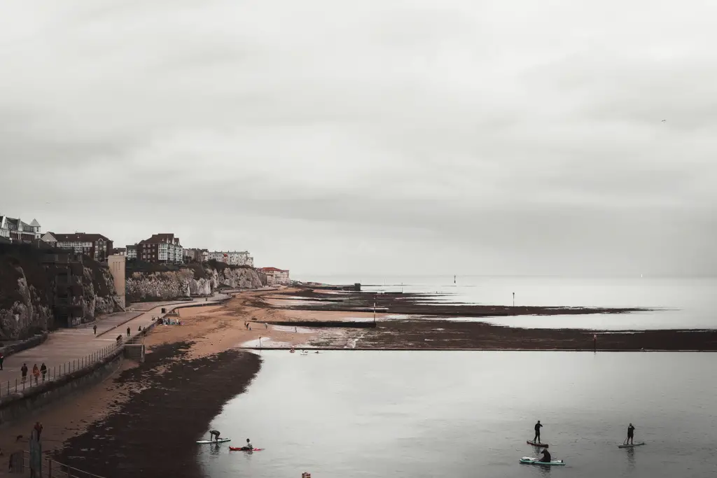 A view of stand up paddle boarders with margate in the distance, on the walk from Margate to Ramsgate.