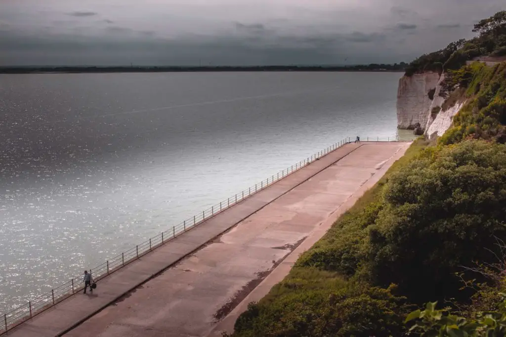 A view from the cliffs of a walkway with two people on the Ramsgate to Sandwich walk.