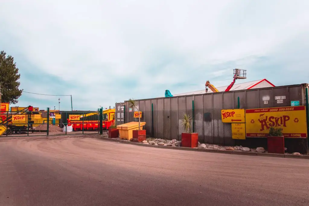 The entrance to a skip on the walk from Ramsgate to Sandwich. The skip has bright yellow and red signage.