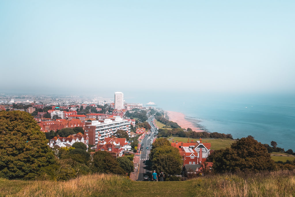 A view looking down over Eastbourne on the walk from Seaford. There is a long road separating the main town and houses from the sea.