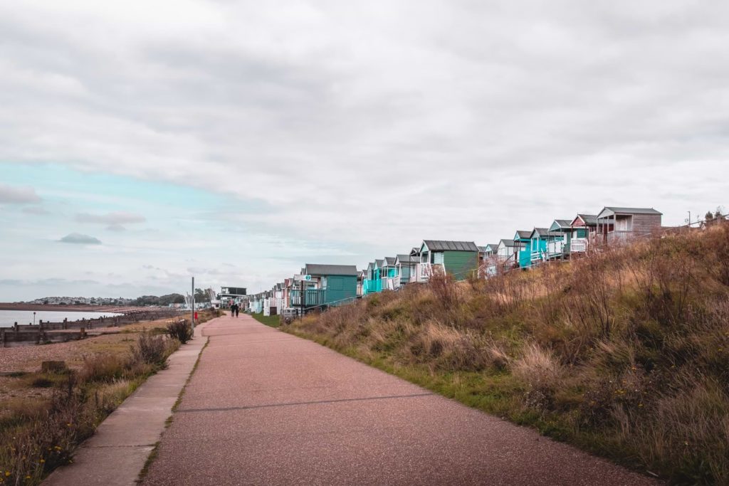 The coastal walking trail from Whitstable to Herne Bay, with a view of beach huts up ahead.