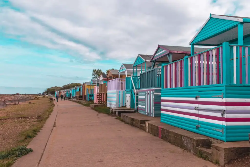 The whitstable to Herne Bay walking trail lined with colourful beach huts on the right.