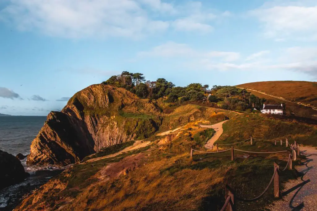 A small with cottage at the end of the trail, with the Lulworth cliffs on the left.