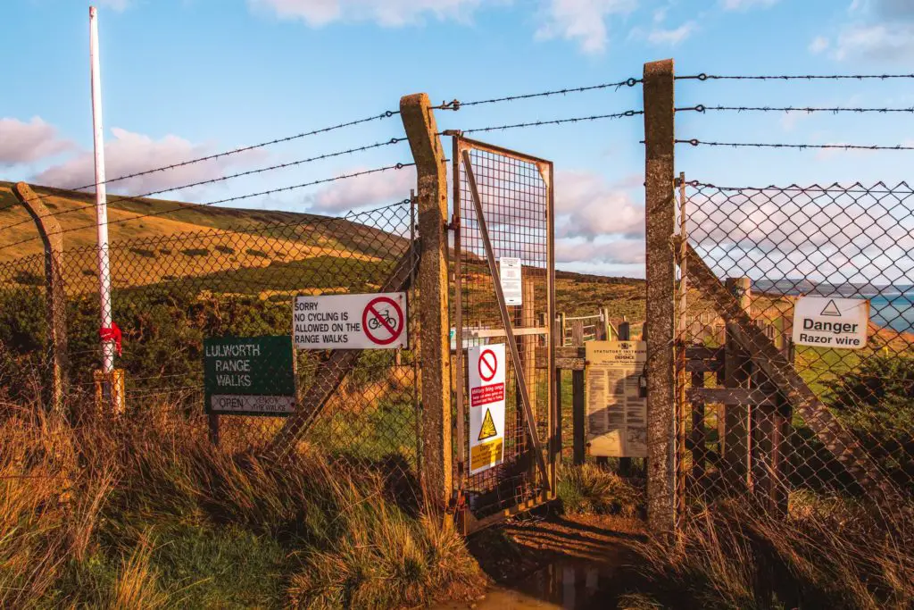 The fence with barbed wire on the top marking the entrance to the army ranges on the Lulworth Cove hike.