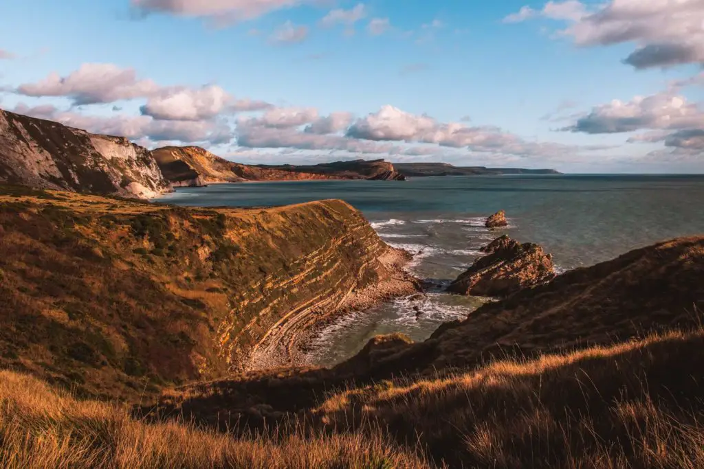 A rocky coastline on the Lulworth Cove hike. the coastline stretches for miles and a few rock formations jutting out of the water.