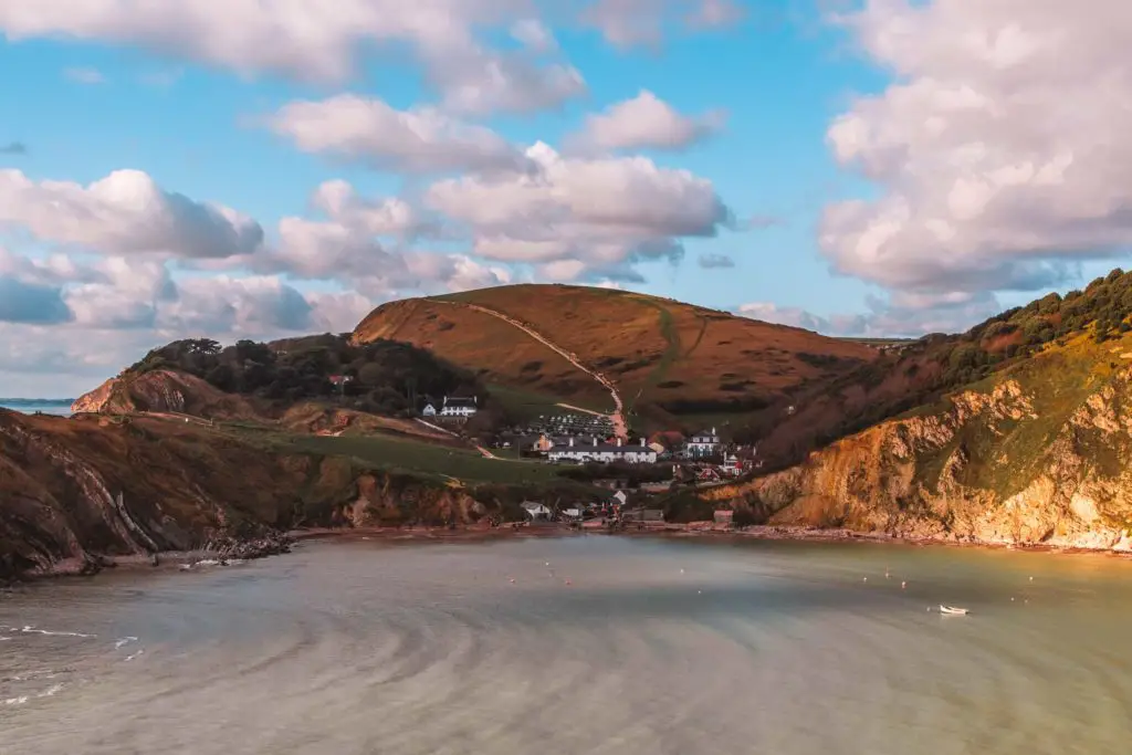 A view of the cluster of buildings in the valley of Lulworth cove, on the other side of the water. 