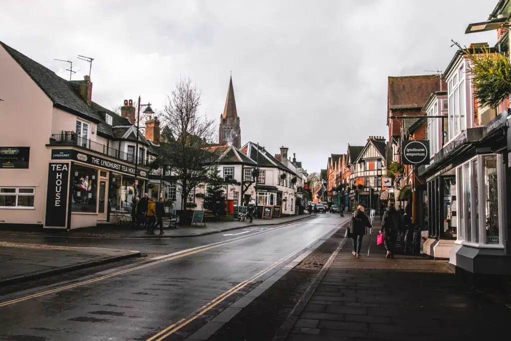 The village of Lyndhurst in the New Forest on a cloudy day. There people walking along the pavement.