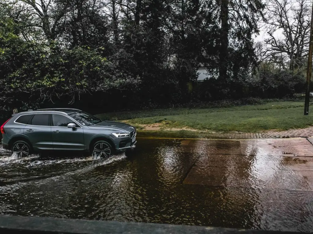 A car driving through the watersplash in Brockenhurst village at the start of the walk.