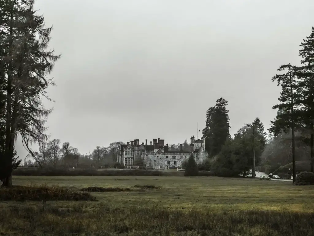 The Rhinefield House Hotel on the other side of a green field in the New Forest.