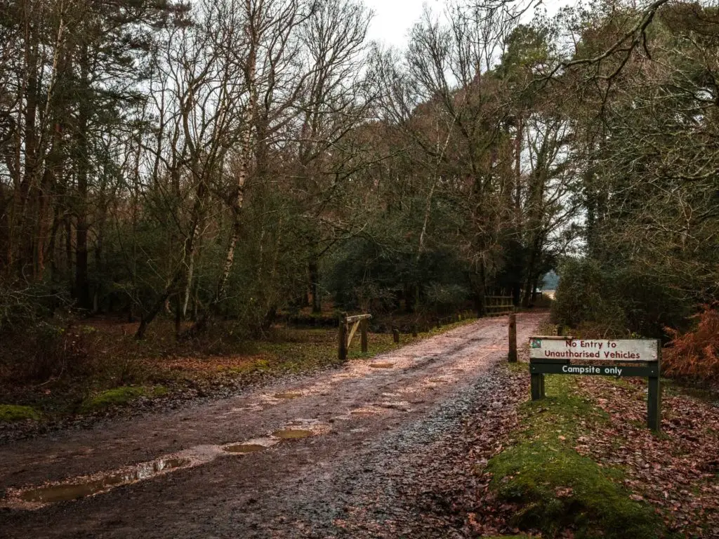 A walking trail leading to the campsite with campsite signage in the New Forest.