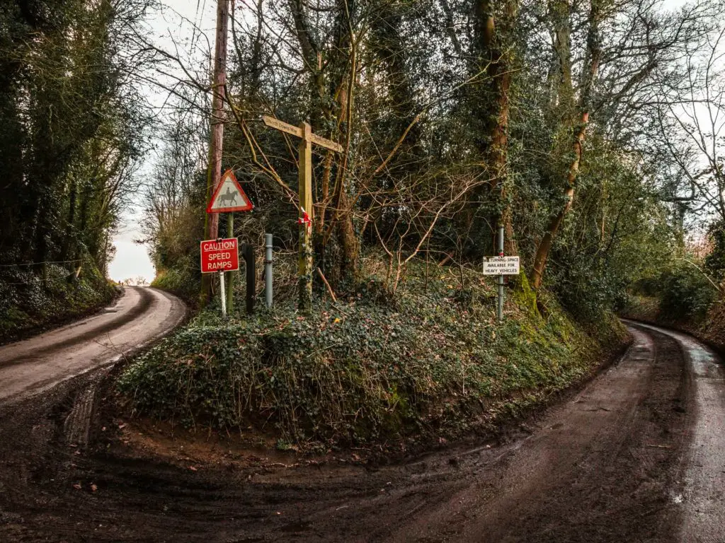 A horse shoe bend with North Downs Way signage in the greenery in the bend.