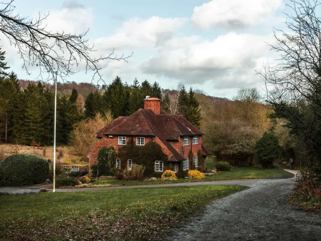 A cute house surrounded by green and trees on the walk from Farnham to Guildford along the North Downs Way.