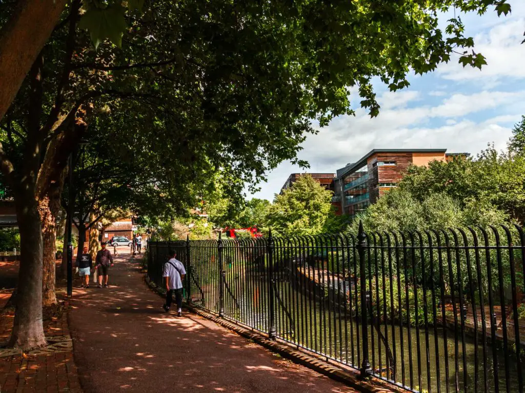 The walking path with black metal fence along the right and the Regents canal down below.