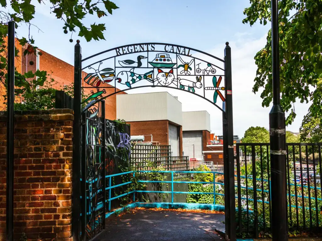 A metal archway gate leading to the Regents Canal along the walk from Little Venice to Camden in London.