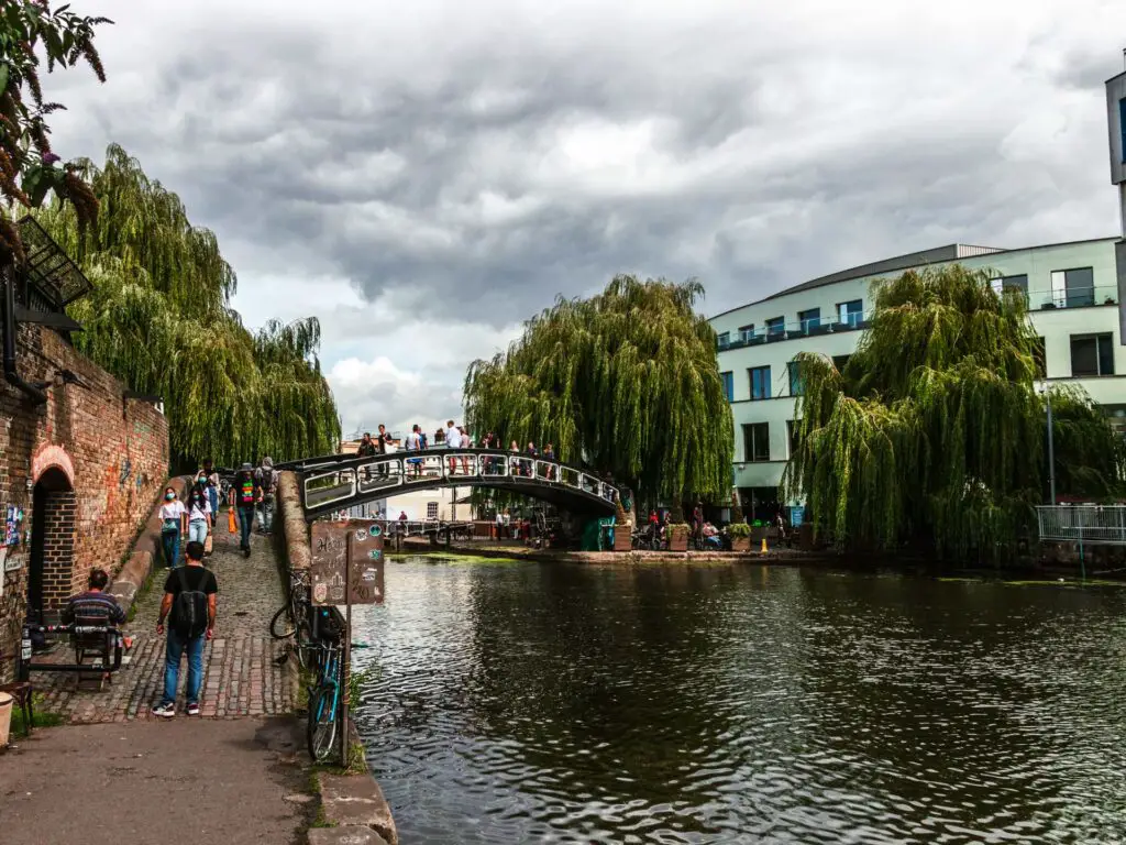 The Canal leading into Camden. There is a bridge up ahead and a few overhanging trees.