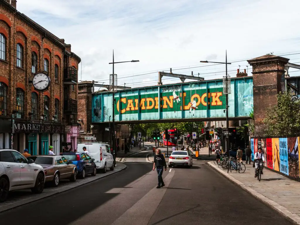 The road in London with a railway bridge up ahead and Camden Lock written on it.