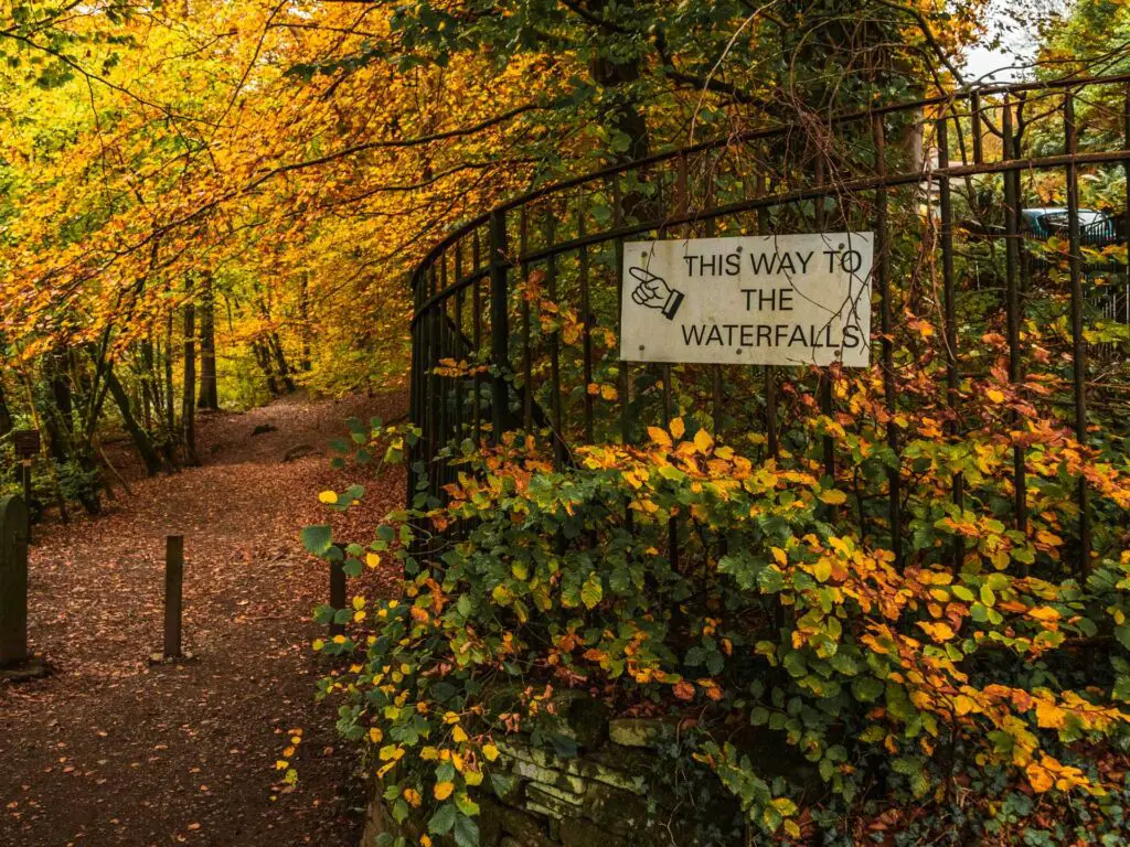 The waterfall signpost on railings pointing the direction for the walk.