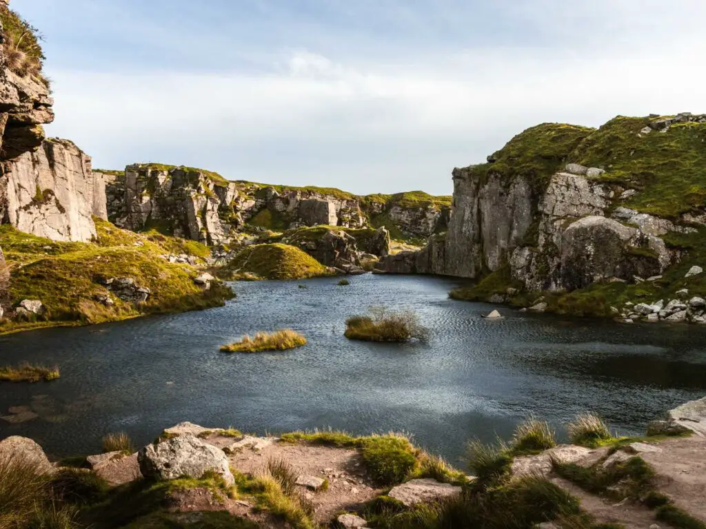 Looking across the water of Foggintor Quarry surrounded by cliffs on one of the best walks in Dartmoor National Park