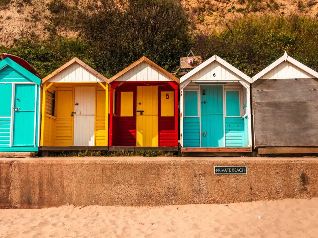 Colourful beach huts next to the sand at Swanage bay.