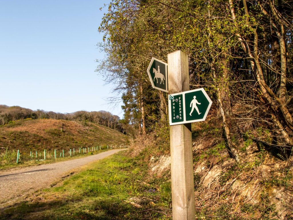 A wooden signpost pointing to the footpath and horse riding path