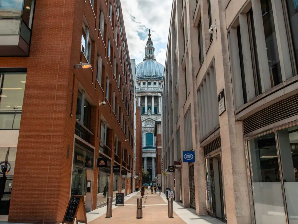 St Pauls Cathedral visible through a narrow alley between the shops on the City of London walk.
