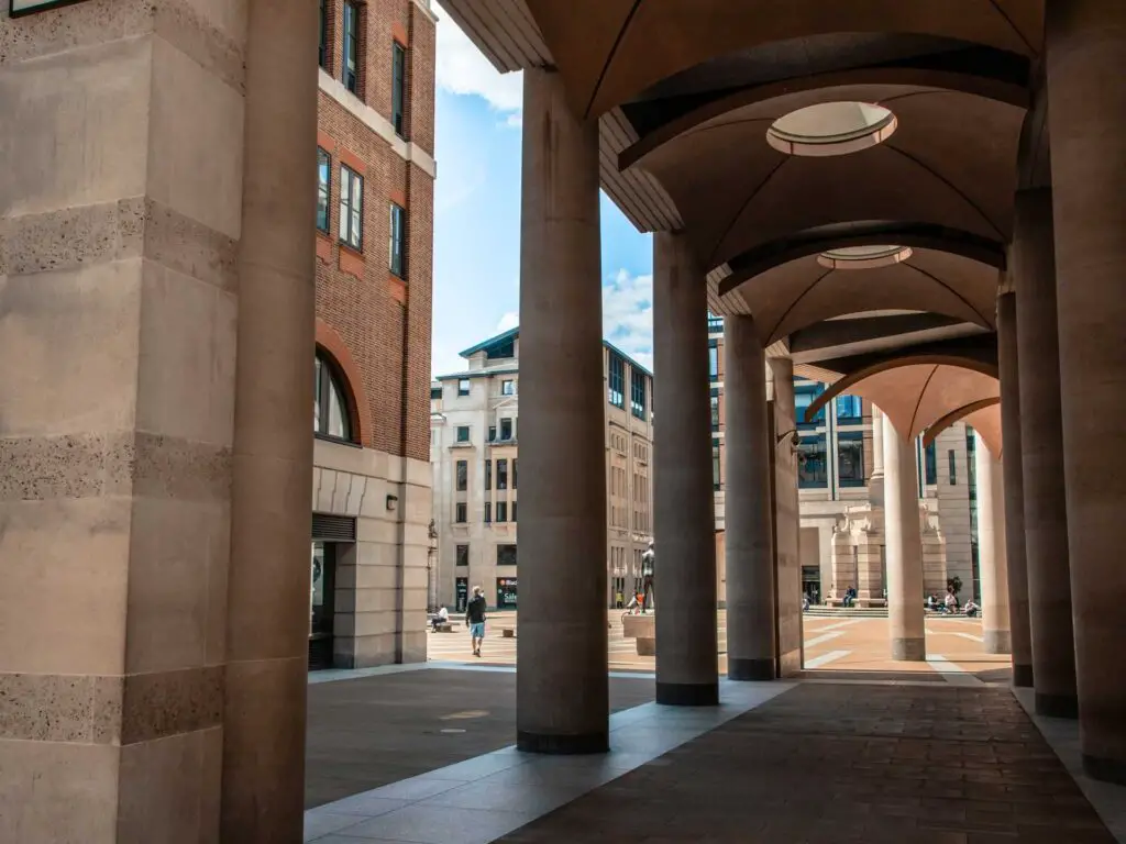 Stone pillars leading to an opening of Paternoster Square on the walk around the city of London.