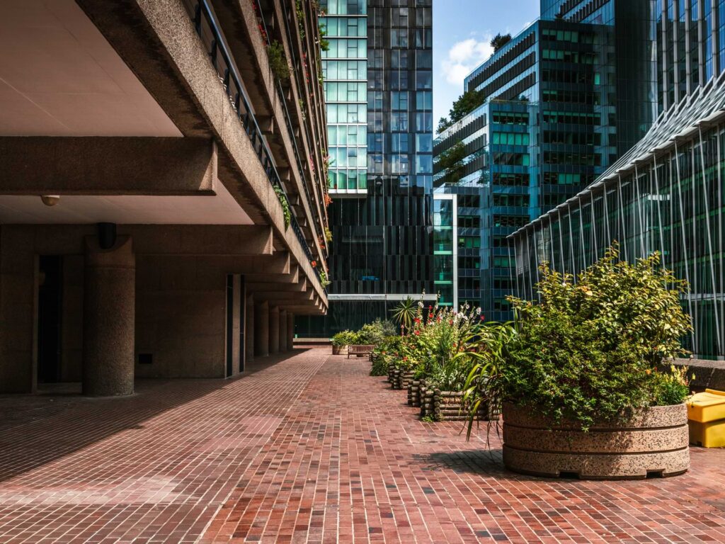 A tile walkway surrounded by glass windowed buildings in the City of London. 