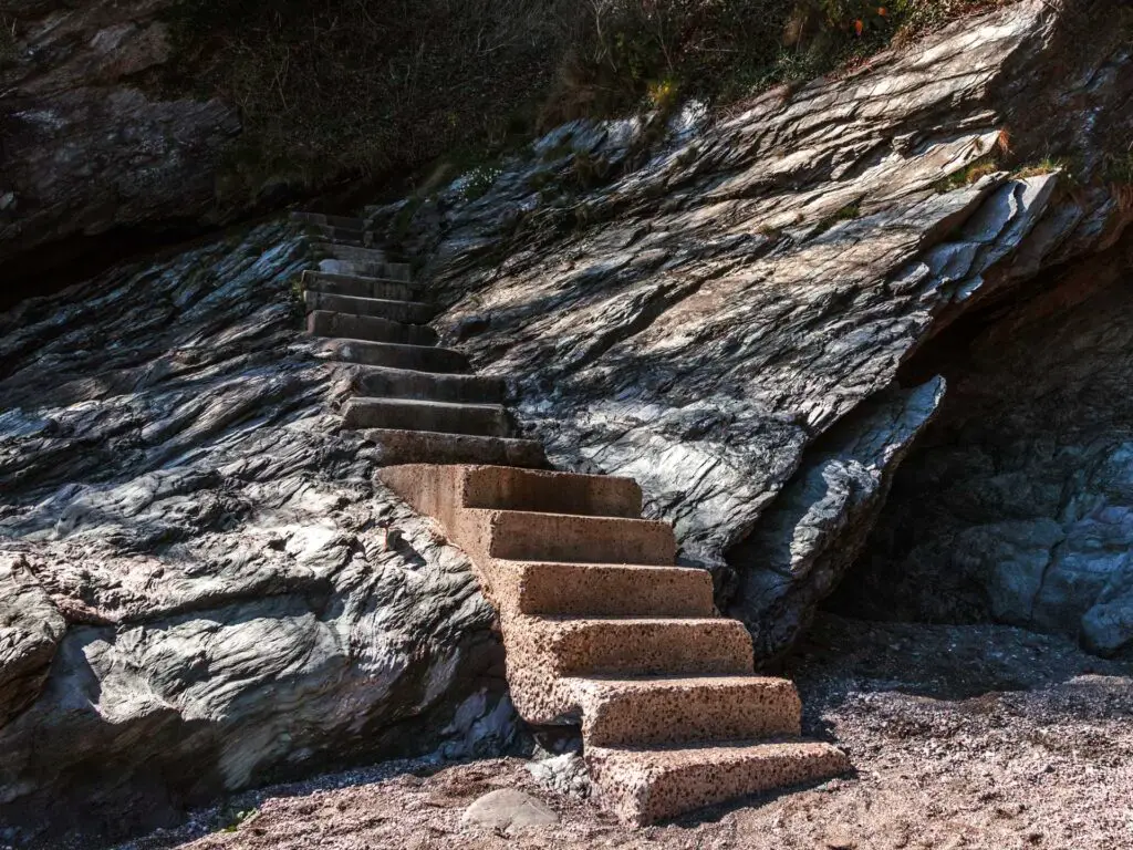 concrete steps on the side of the black rocks on the walk down to Sugary cove in Dartmouth.