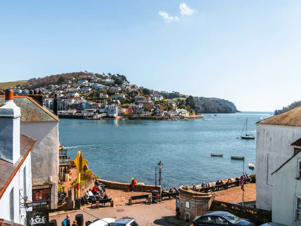 Looking through some buildings in Dartmouth across the River Dart to the peninsular on the other side. There are lots of houses on the hill on the other side of the river.