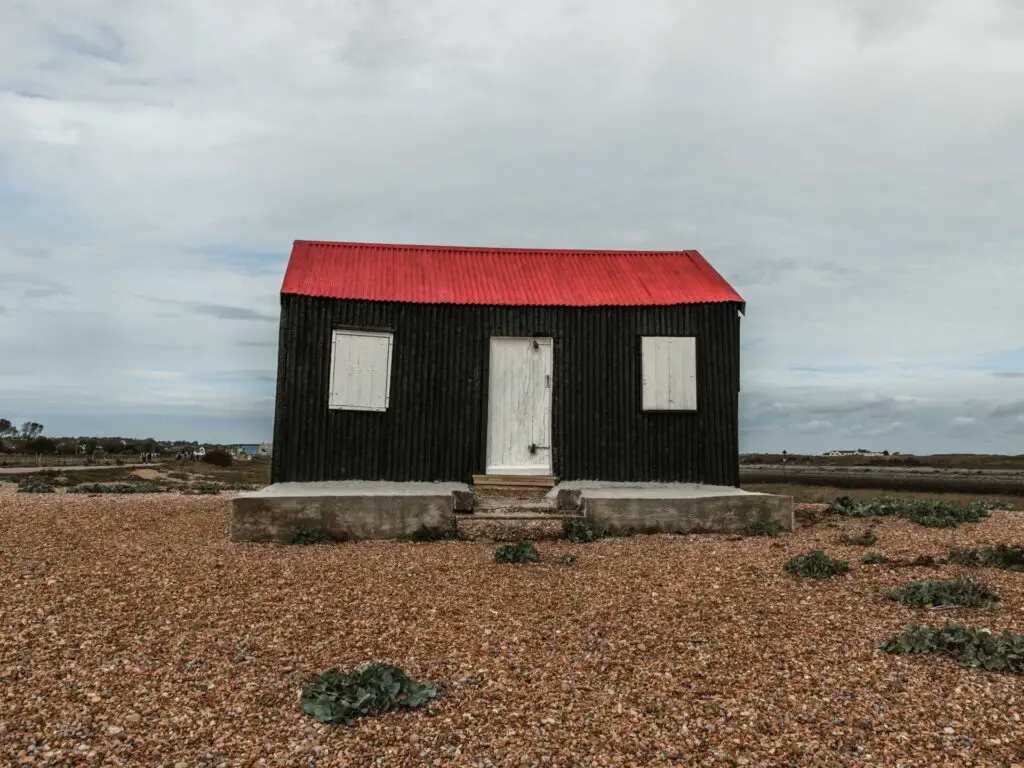 A black shed with a red roof on the walk to Rye Harbour and Camber Castle