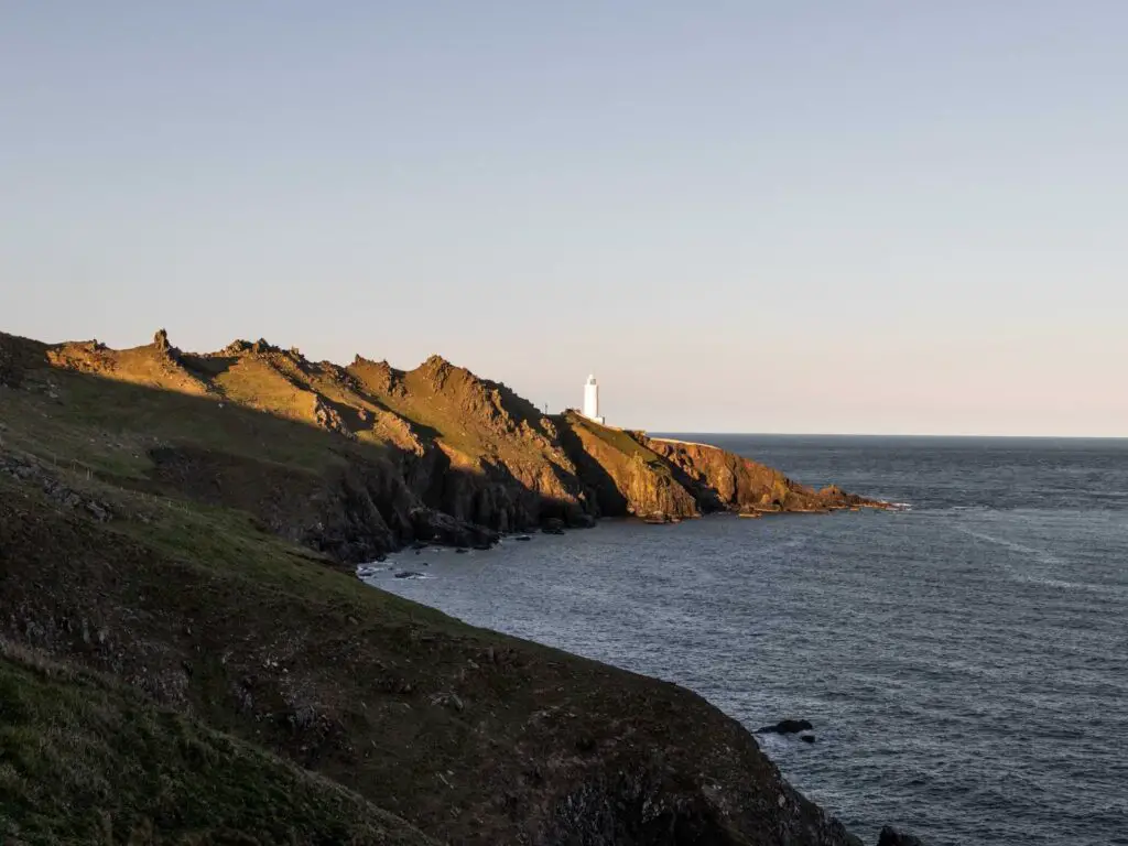 A view across the rocky peninsula with the white start point lighthouse visible on the tip. 