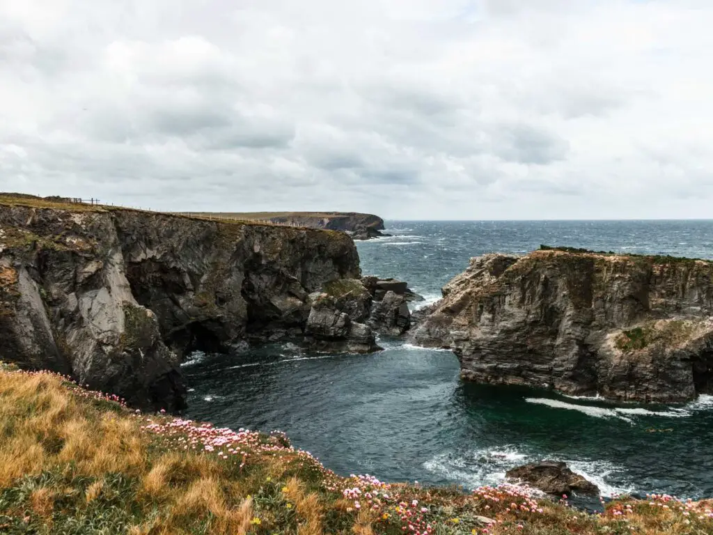 Rugged cliff and rocks in the sea off the coast of Cornwall.