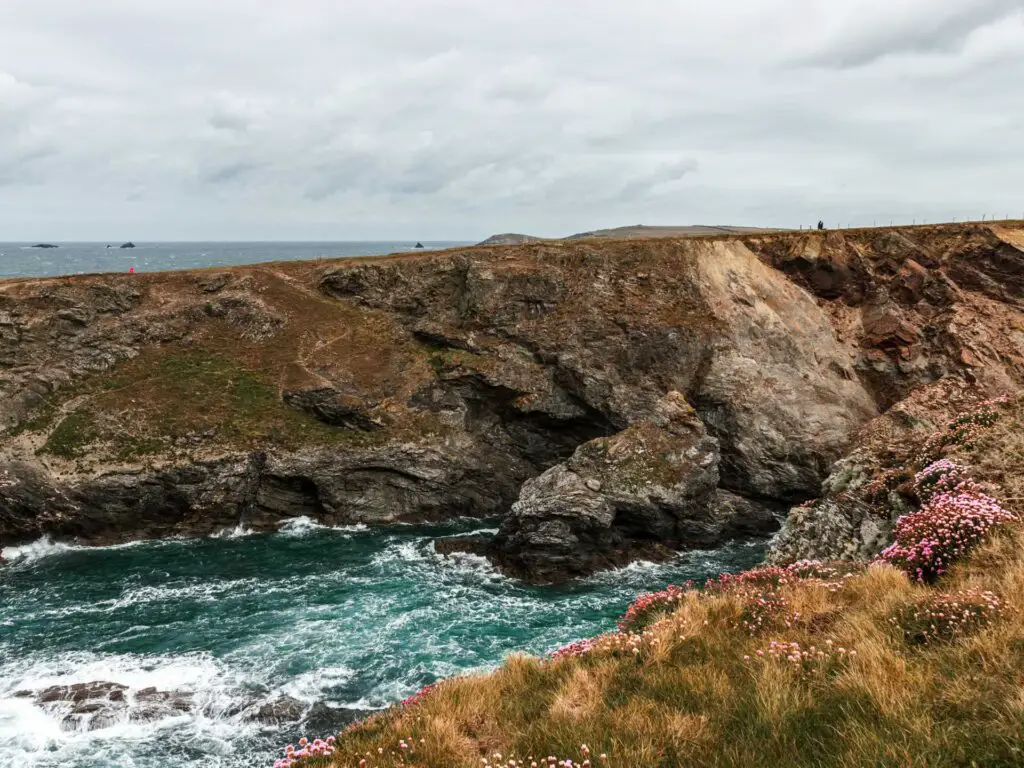 Looking across the rough sea to the rugged cliff cove on the walk into Treyarnon.