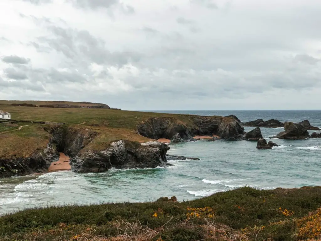 The blue sea running through the rugged cliffs on the walk from Porthcothan in Cornwall.