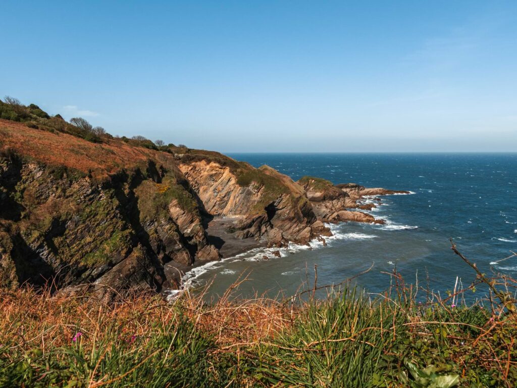 The rocky cliff coastline where it meets the blue sea in North Devon.