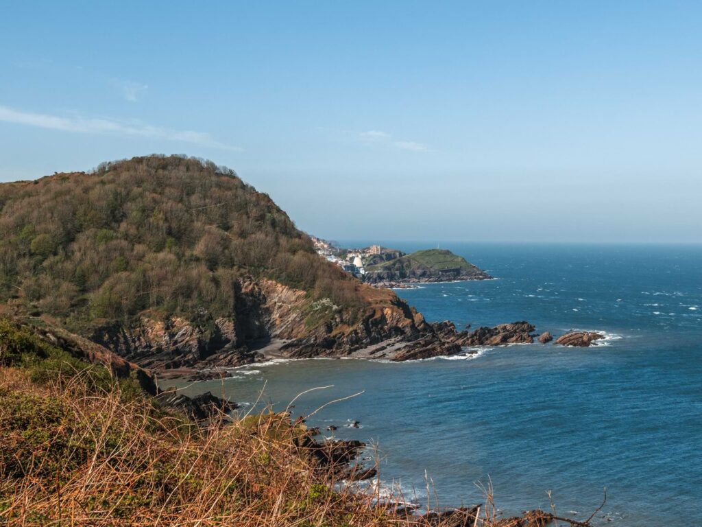 The hilly, cliff coastline where it meets the blue sea, near Ilfracombe at the start of the walk towards watermouth. 