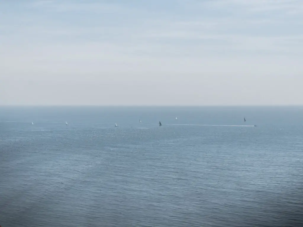 Sail boats out in the blue see on the walk along the coast path from Kimmeridge Bay.