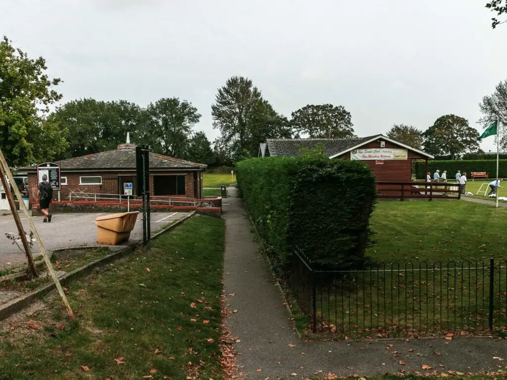 A small path running between the bowels green and the car park.