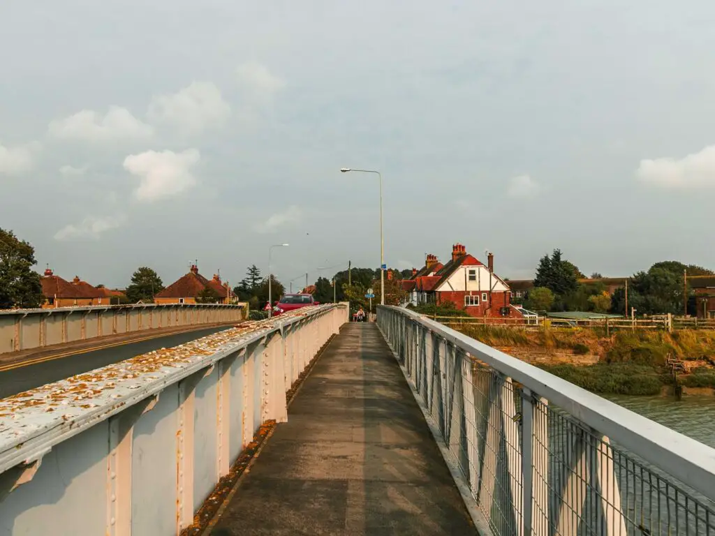 The bridge path with metal railings on either side on the walk out of Rye towards Camber Sands.